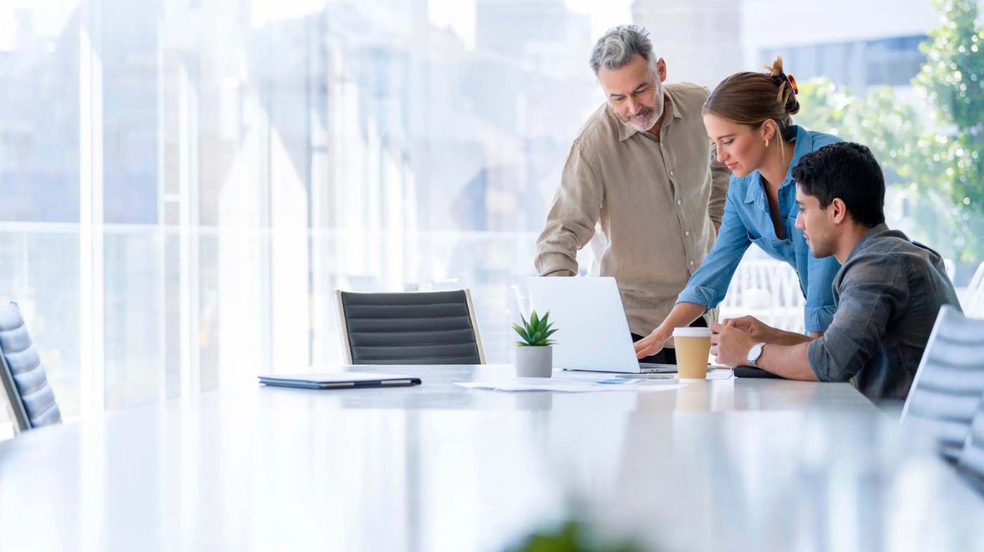 Three people are having a joint discussion in a meeting room.